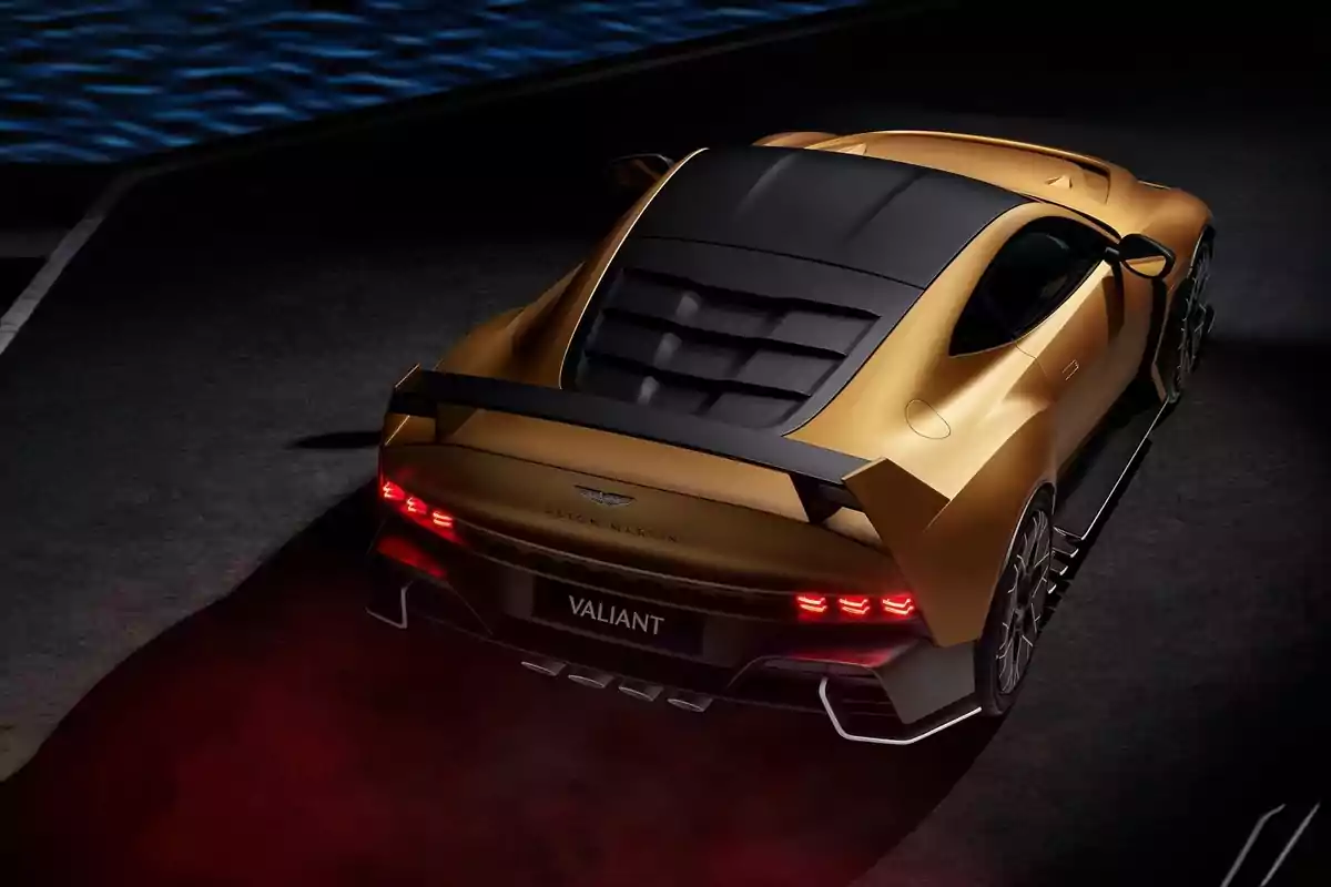 Un coche deportivo dorado de lujo visto desde atrás en un entorno oscuro con luces traseras encendidas.