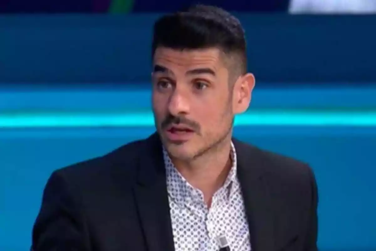 Hombre con barba y cabello oscuro en un estudio de televisión.