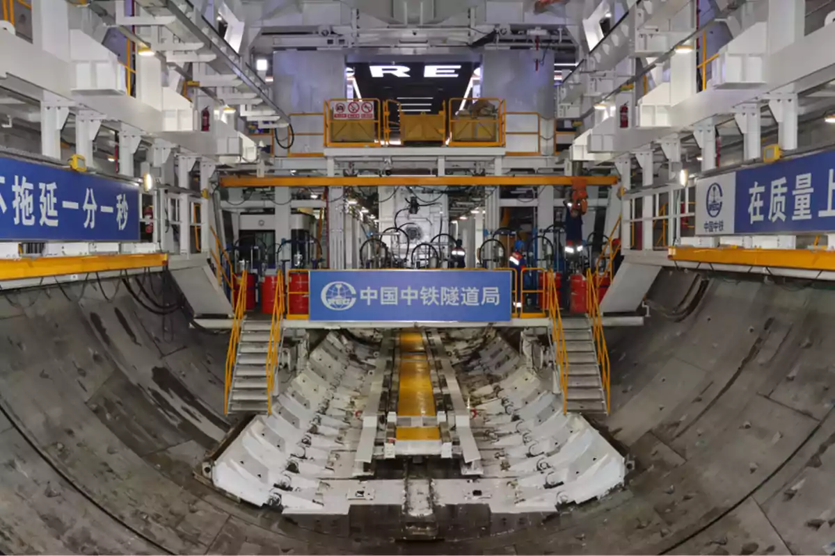 Interior de una tuneladora en una obra de construcción subterránea con maquinaria y estructuras metálicas.