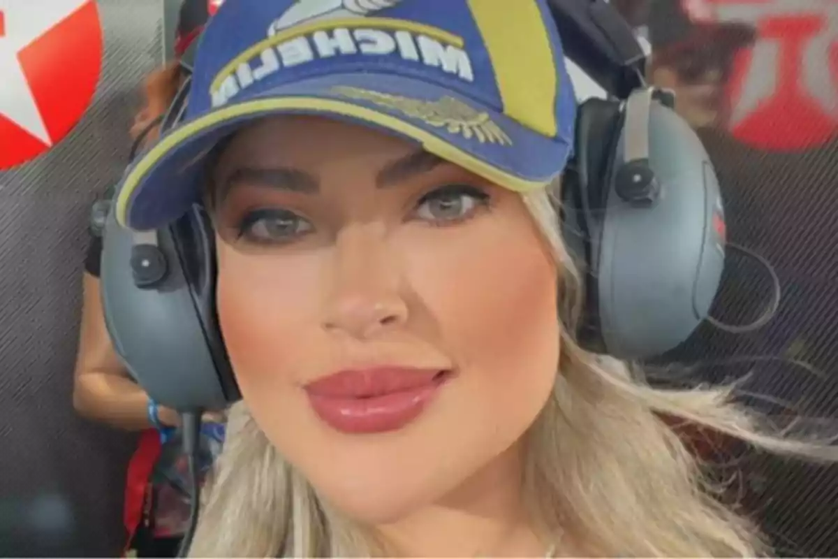 Una persona con gorra y auriculares grandes en un entorno posiblemente relacionado con automovilismo. Una persona con gorra y auriculares grandes en un entorno posiblemente relacionado con automovilismo.
