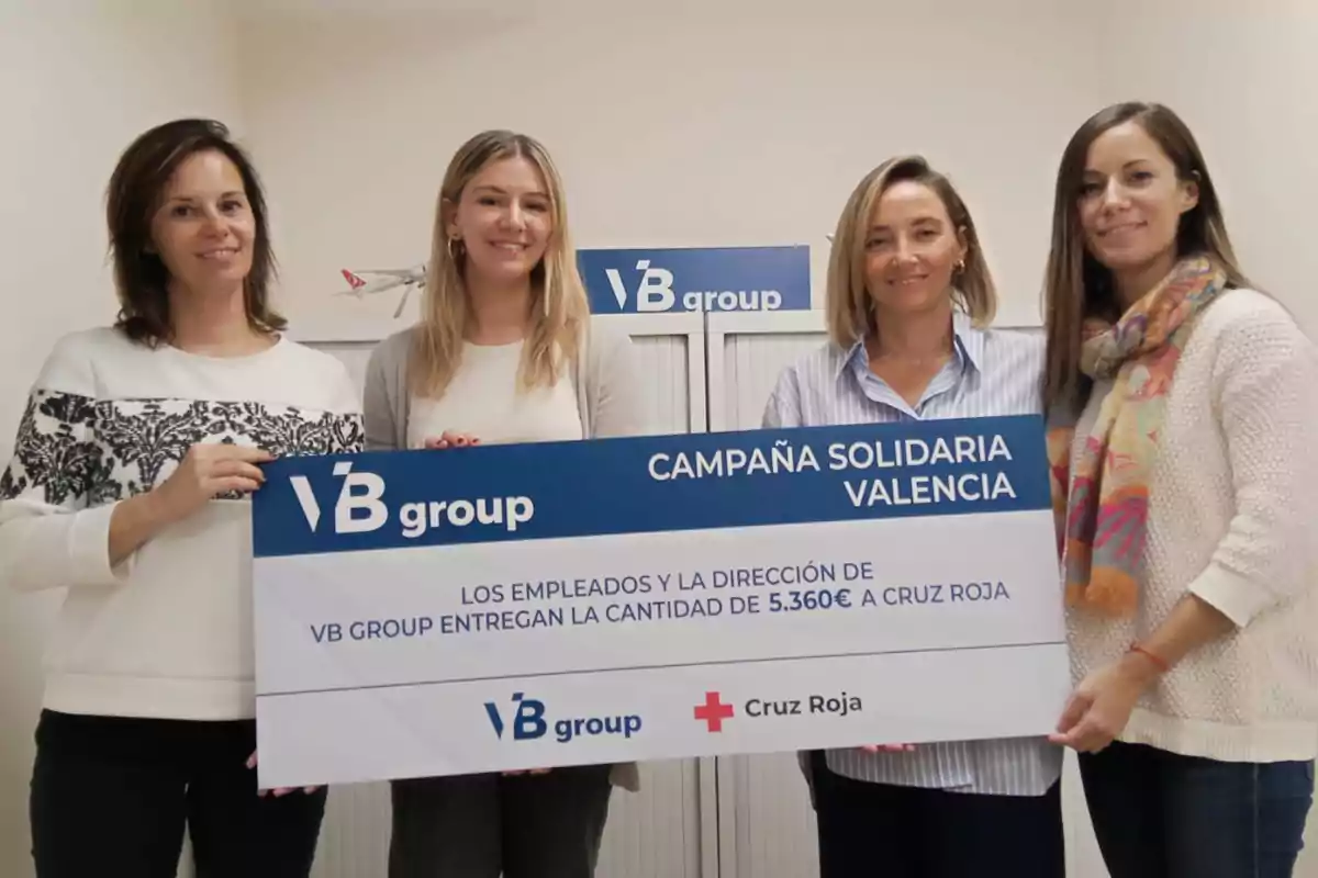 Cuatro personas sostienen un cheque grande de VB Group para la Cruz Roja, con un monto de 5,360 euros, en el contexto de una campaña solidaria en Valencia.