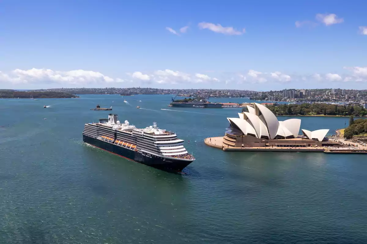 Un crucero navegando cerca de la Ópera de Sídney en un día soleado.