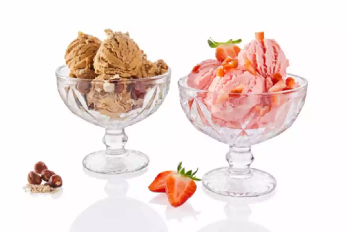 Dos copas de helado, una de sabor chocolate con avellanas y otra de fresa con trozos de fresa, sobre fondo blanco Dos copas de helado, una de sabor chocolate con avellanas y otra de fresa con trozos de fresa, sobre fondo blanco