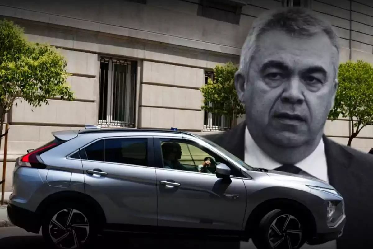 Un automóvil gris estacionado frente a un edificio con ventanas y árboles, con el rostro en blanco y negro de un hombre superpuesto en la parte superior derecha