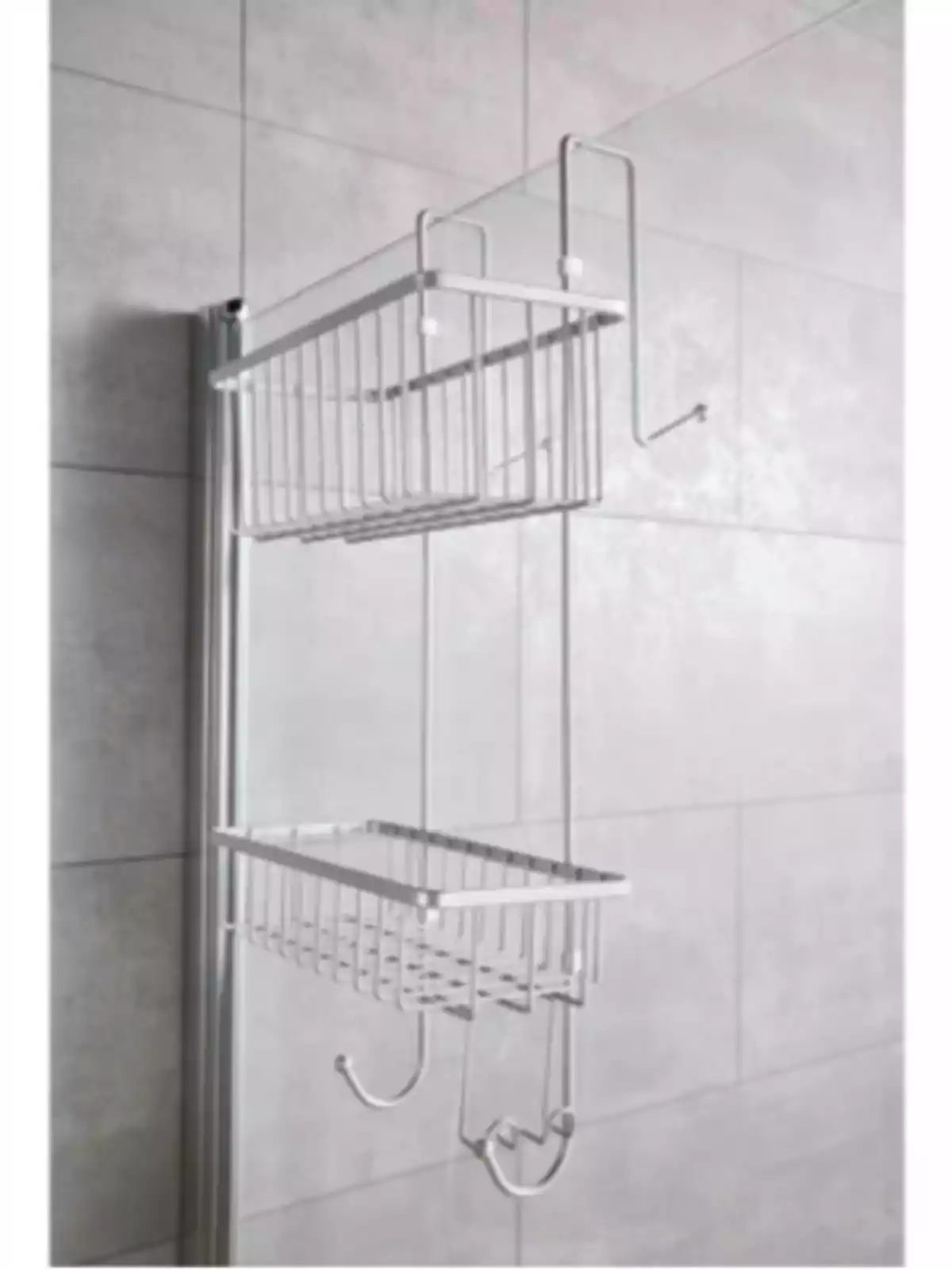 Organizador metálico de dos niveles colgado en una puerta de vidrio en un baño con paredes de azulejo gris Organizador metálico de dos niveles colgado en una puerta de vidrio en un baño con paredes de azulejo gris