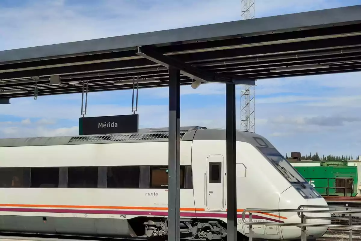 Tren de pasajeros detenido en la estación de Mérida bajo un cielo parcialmente nublado Tren de pasajeros detenido en la estación de Mérida bajo un cielo parcialmente nublado