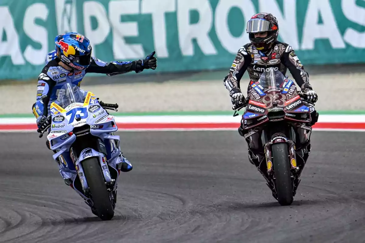 Dos motociclistas compitiendo en una pista, uno de ellos levantando el pulgar en señal de saludo o reconocimiento al otro piloto Dos motociclistas compitiendo en una pista, uno de ellos levantando el pulgar en señal de saludo o reconocimiento al otro piloto