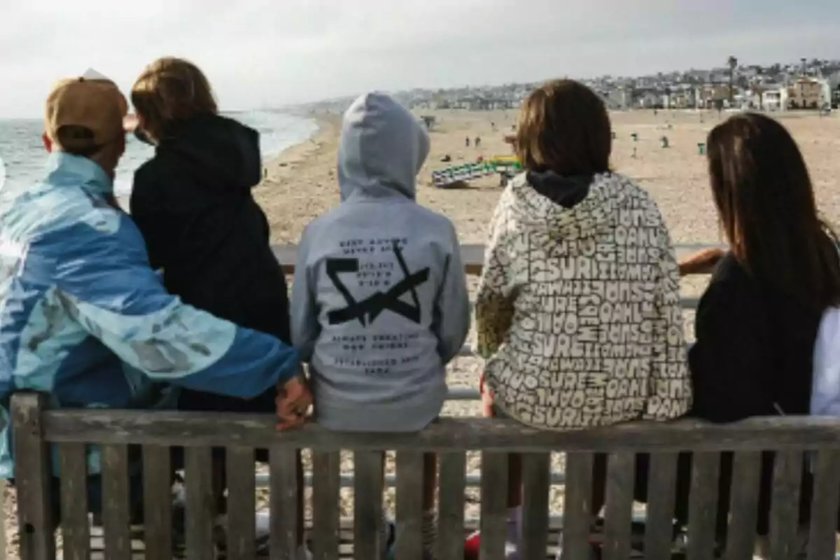 Cinco personas sentadas en una banca de madera mirando hacia la playa -que son Pilar Rubio, Sergio Ramos y sus tres hijos- en un día nublado. Cinco personas sentadas en una banca de madera mirando hacia la playa -que son Pilar Rubio, Sergio Ramos y sus tres hijos- en un día nublado.