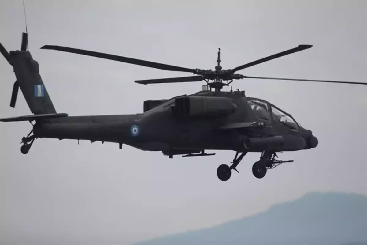 Helicóptero militar en vuelo con insignias nacionales sobre un fondo de cielo nublado y montañas difusas. Helicóptero militar en vuelo con insignias nacionales sobre un fondo de cielo nublado y montañas difusas.