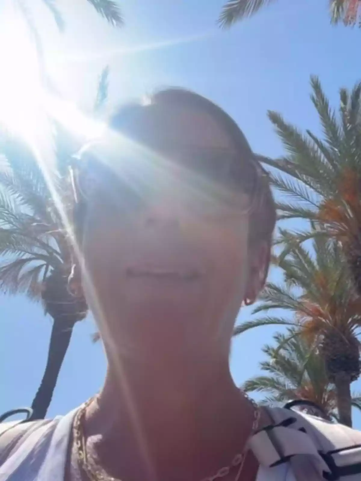 Anabel Pantoja con gafas de sol bajo la luz intensa del sol rodeada de palmeras y cielo azul Anabel Pantoja con gafas de sol bajo la luz intensa del sol rodeada de palmeras y cielo azul