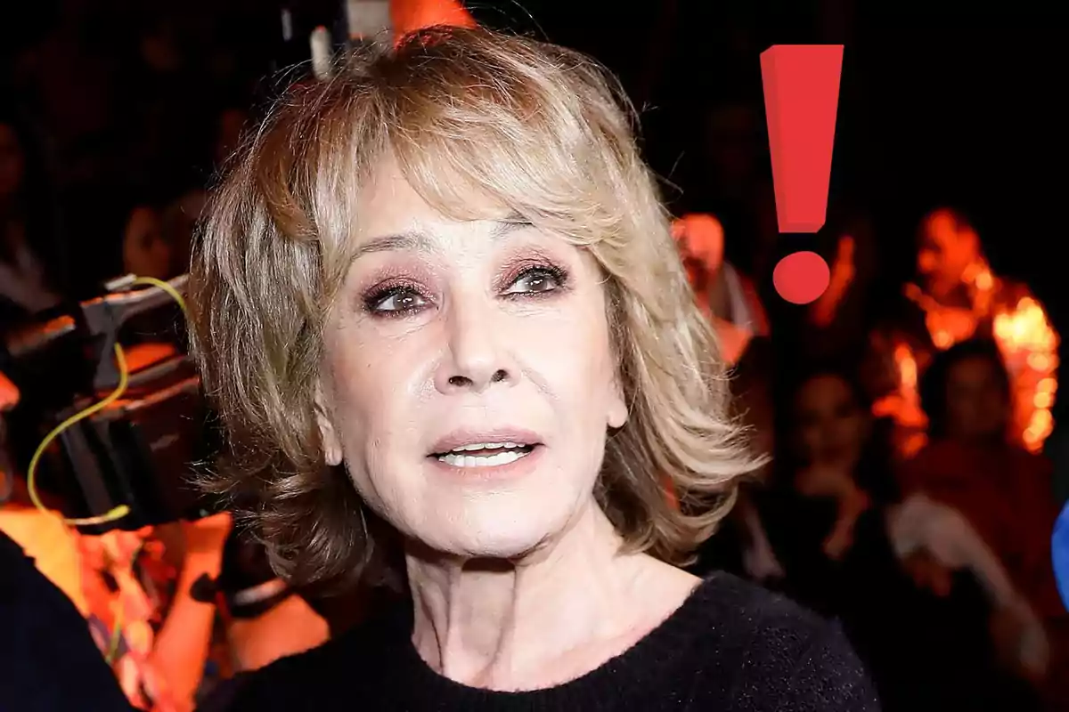 Mila Ximénez de cabello rubio corto con expresión seria en un evento con un signo de exclamación rojo al fondo