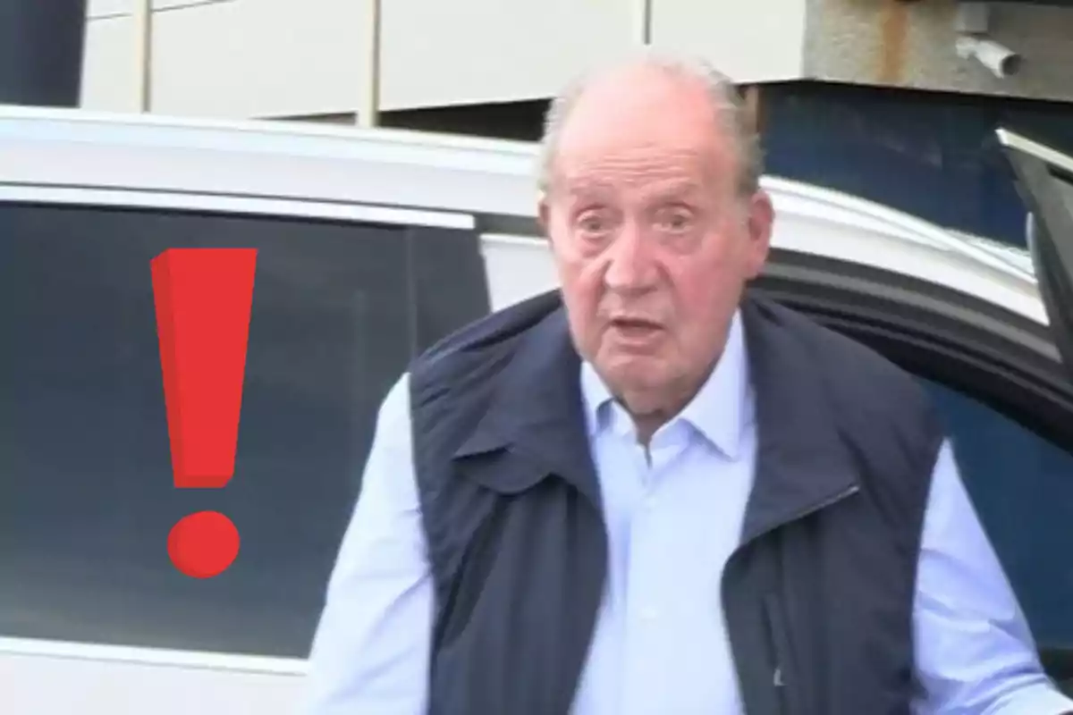 Older man with a surprised expression next to a large red exclamation mark in front of a white car