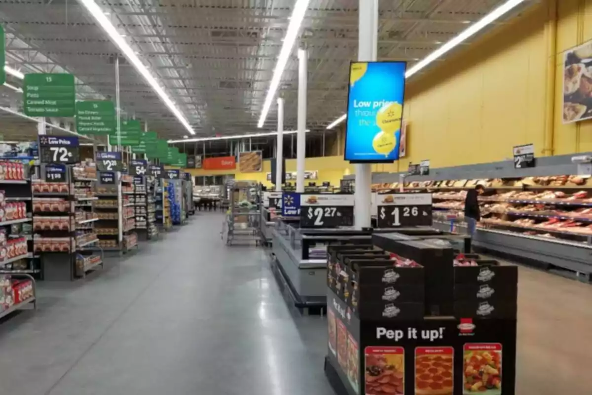 Supermarket aisle with shelves full of products and low price signage Supermarket aisle with shelves full of products and low price signage