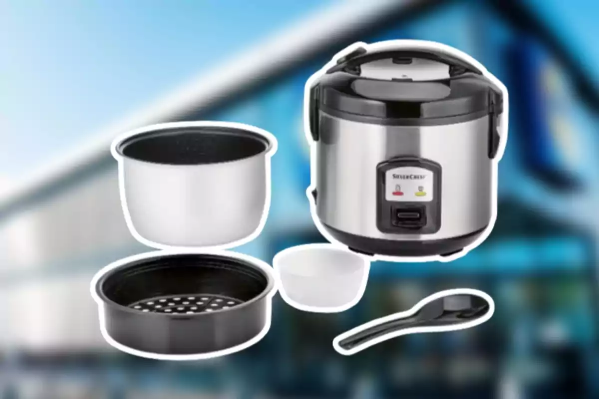 Olla arrocera eléctrica de acero inoxidable con accesorios como recipiente interior, bandeja para vapor, taza medidora y cuchara sobre un fondo desenfocado. Olla arrocera eléctrica de acero inoxidable con accesorios como recipiente interior, bandeja para vapor, taza medidora y cuchara sobre un fondo desenfocado.