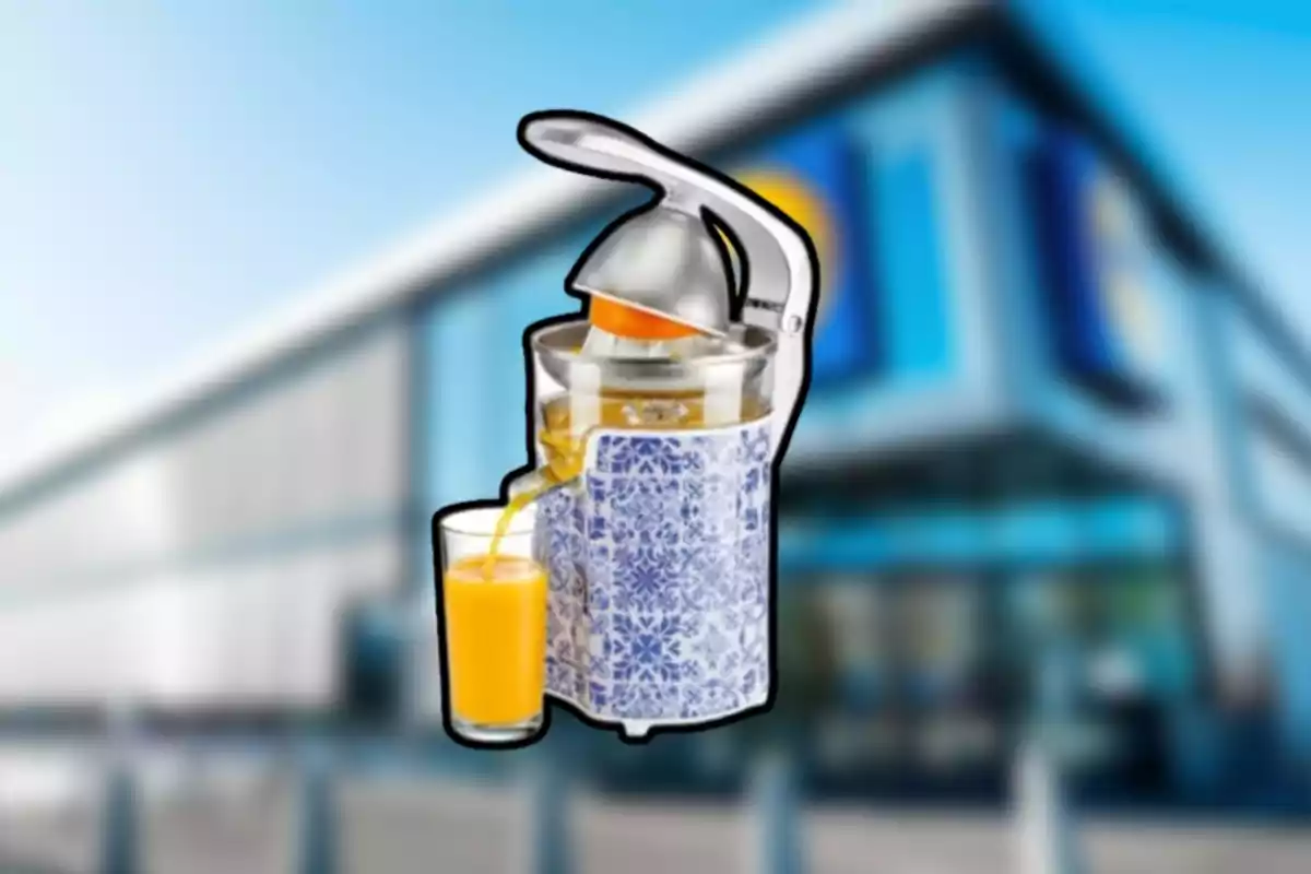 Exprimidor de cítricos decorado con patrones azules sirviendo jugo de naranja en un vaso frente a un edificio desenfocado Exprimidor de cítricos decorado con patrones azules sirviendo jugo de naranja en un vaso frente a un edificio desenfocado