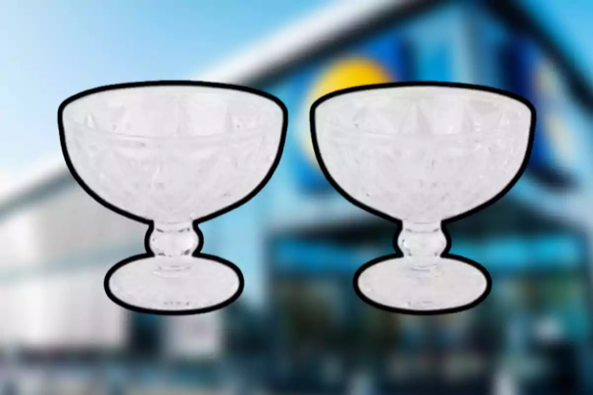 Dos copas de cristal con diseño tallado al frente de un edificio desenfocado Dos copas de cristal con diseño tallado al frente de un edificio desenfocado
