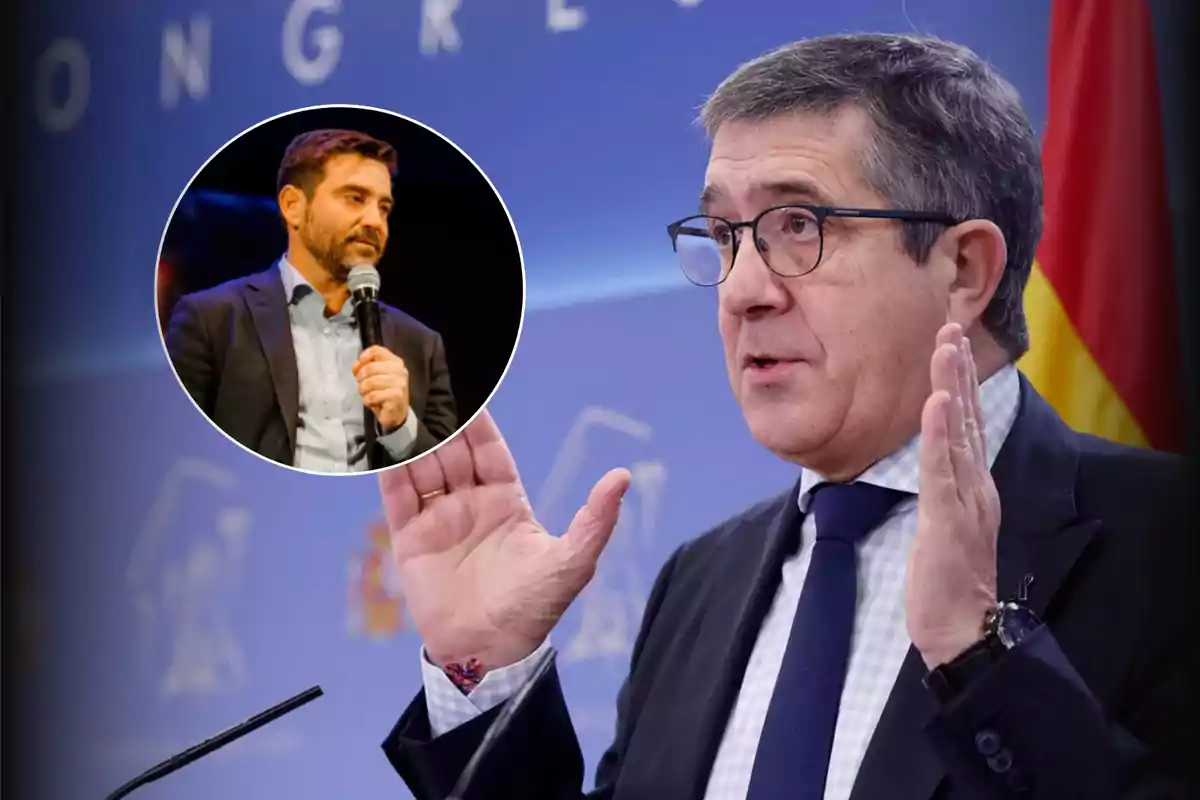Un hombre de traje y gafas habla gesticulando frente a un micrófono con una bandera de fondo y en la esquina superior izquierda aparece un recuadro circular con otro hombre sosteniendo un micrófono