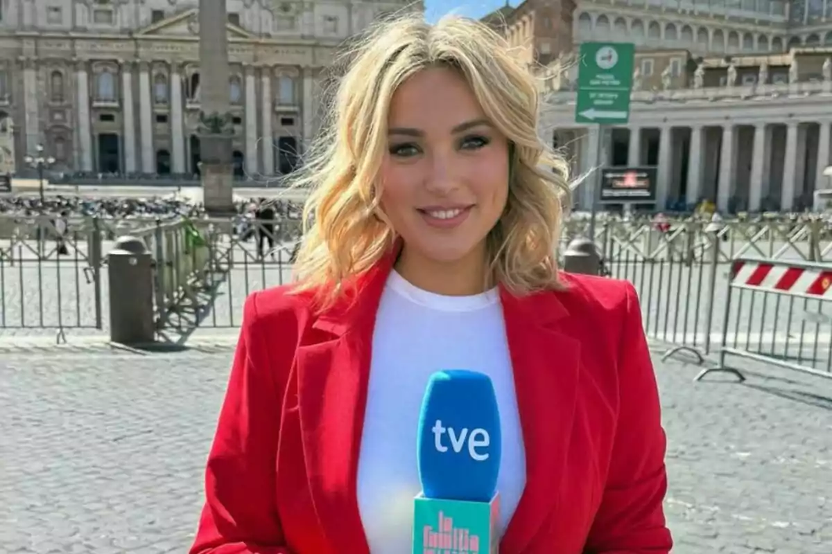 Marta Riesco rubia con chaqueta roja sostiene un micrófono azul de tve de 'La familia de la tele' Marta Riesco rubia con chaqueta roja sostiene un micrófono azul de tve de 'La familia de la tele'