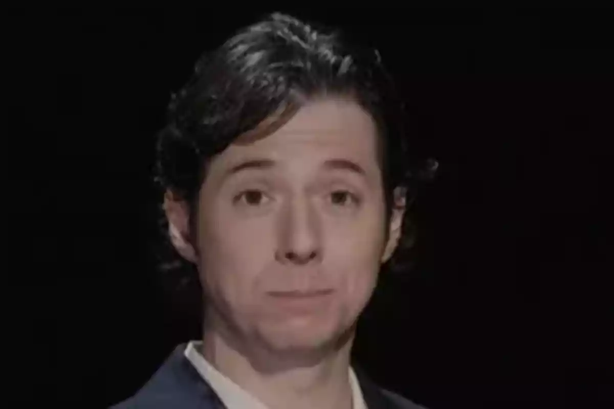 Álvaro Rojo con expresión seria, vistiendo saco oscuro y camisa clara, fondo negro. Álvaro Rojo con expresión seria, vistiendo saco oscuro y camisa clara, fondo negro.