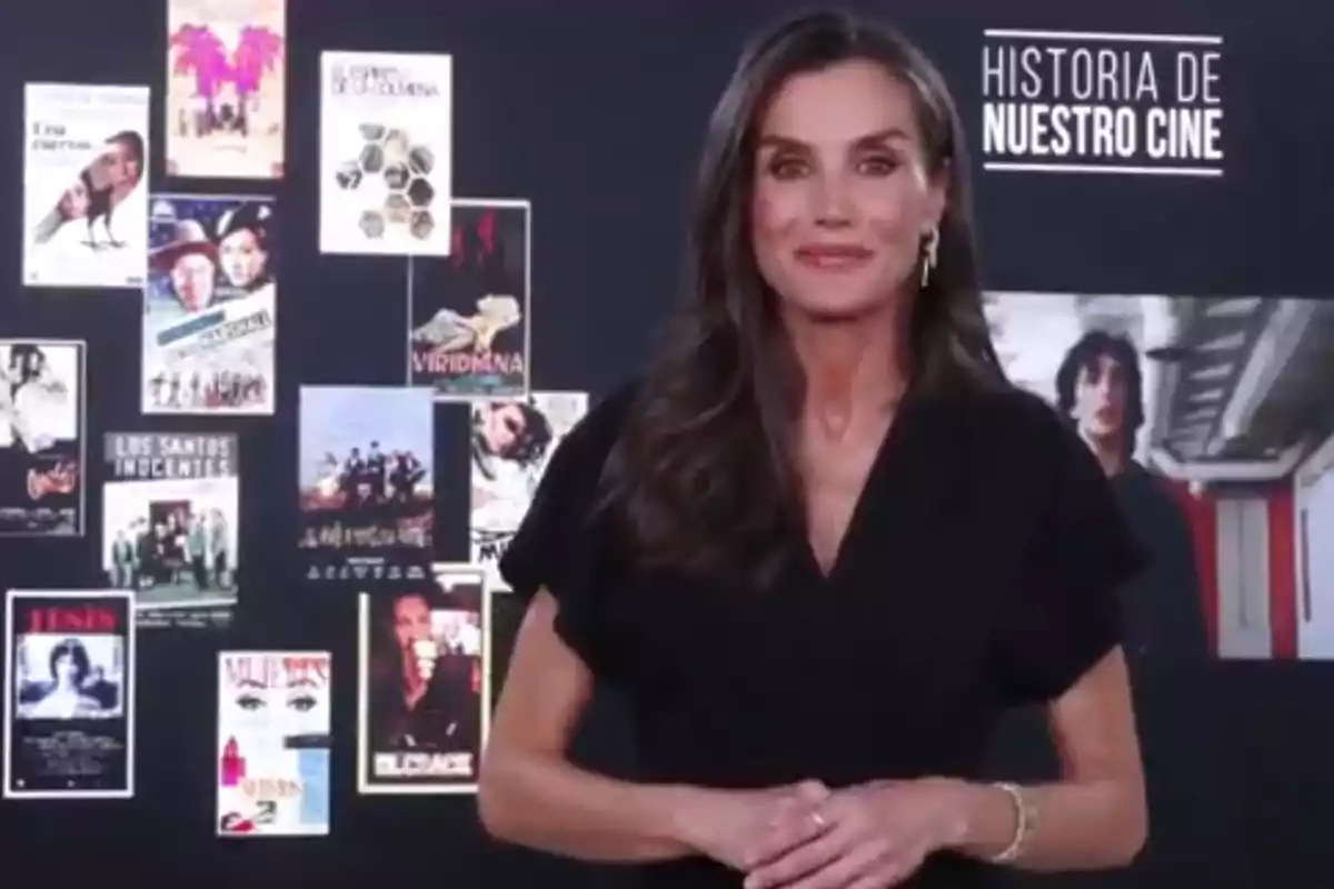 La reina Letizia, vestida de negro, posando frente a un fondo con carteles de películas para felicitar al programa 'Historia de nuestro cine' La reina Letizia, vestida de negro, posando frente a un fondo con carteles de películas para felicitar al programa 'Historia de nuestro cine'