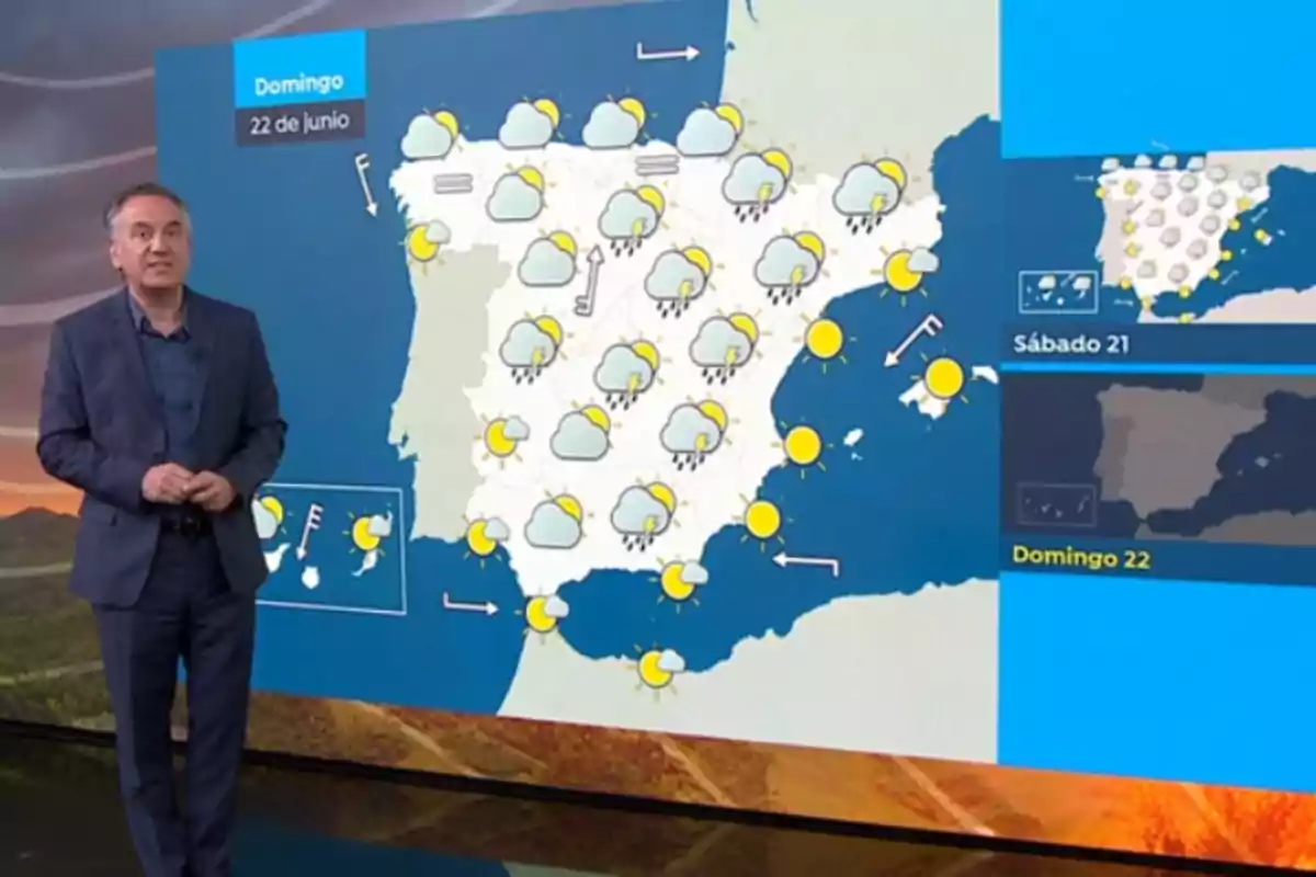 Roberto Brasero está de pie junto a un mapa de España que muestra el pronóstico del tiempo para el domingo 22 de junio con iconos de nubes, sol y lluvia repartidos por diferentes regiones del país. Roberto Brasero está de pie junto a un mapa de España que muestra el pronóstico del tiempo para el domingo 22 de junio con iconos de nubes, sol y lluvia repartidos por diferentes regiones del país.