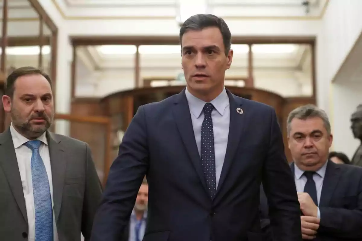 Tres hombres con traje caminando en un edificio gubernamental