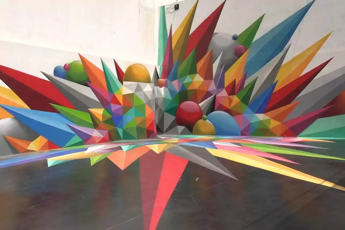 Mural de arte urbano con figuras geométricas coloridas y puntas tridimensionales en una pared y el suelo Mural de arte urbano con figuras geométricas coloridas y puntas tridimensionales en una pared y el suelo