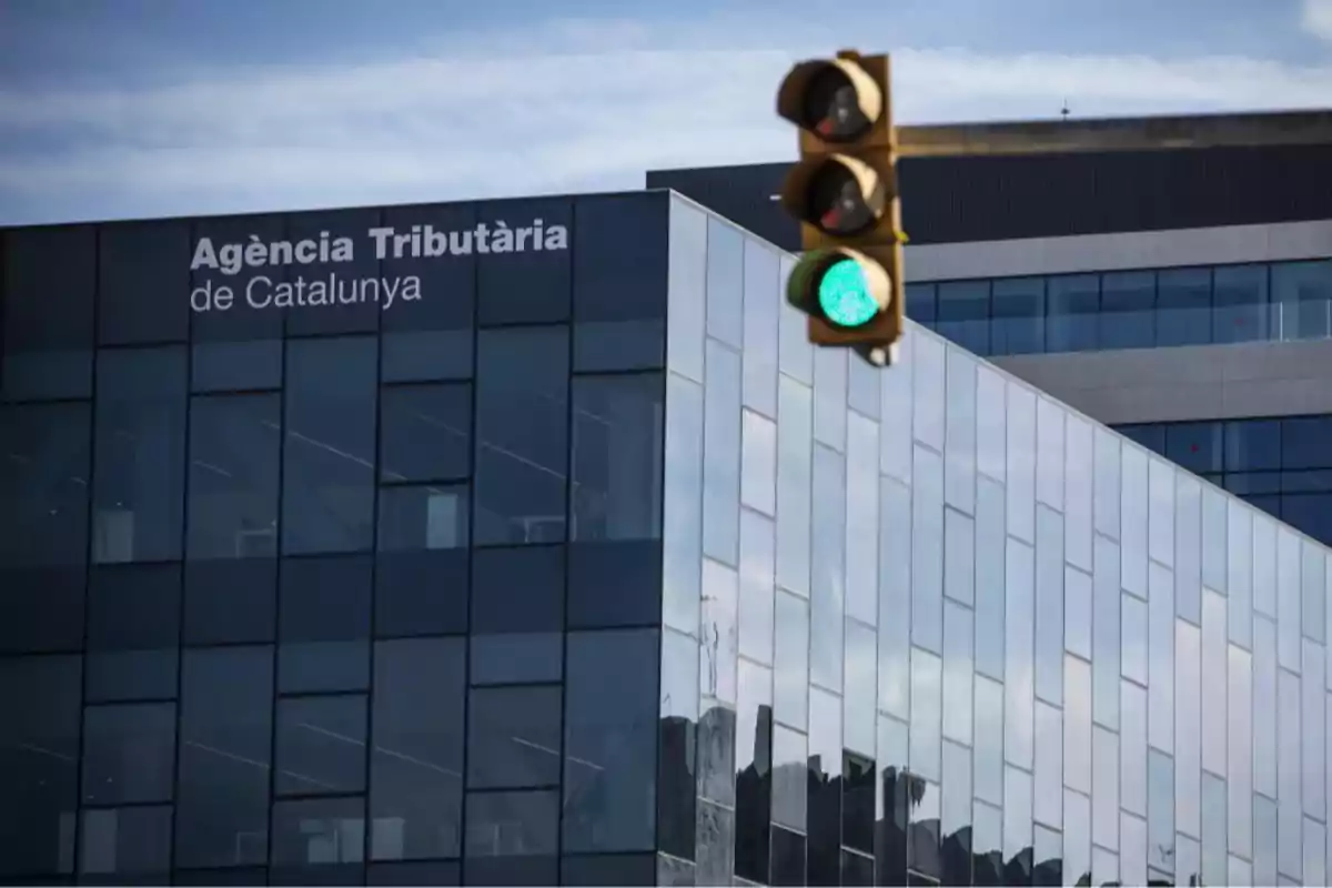 Edificio moderno de la Agència Tributària de Catalunya con un semáforo en verde en primer plano Edificio moderno de la Agència Tributària de Catalunya con un semáforo en verde en primer plano
