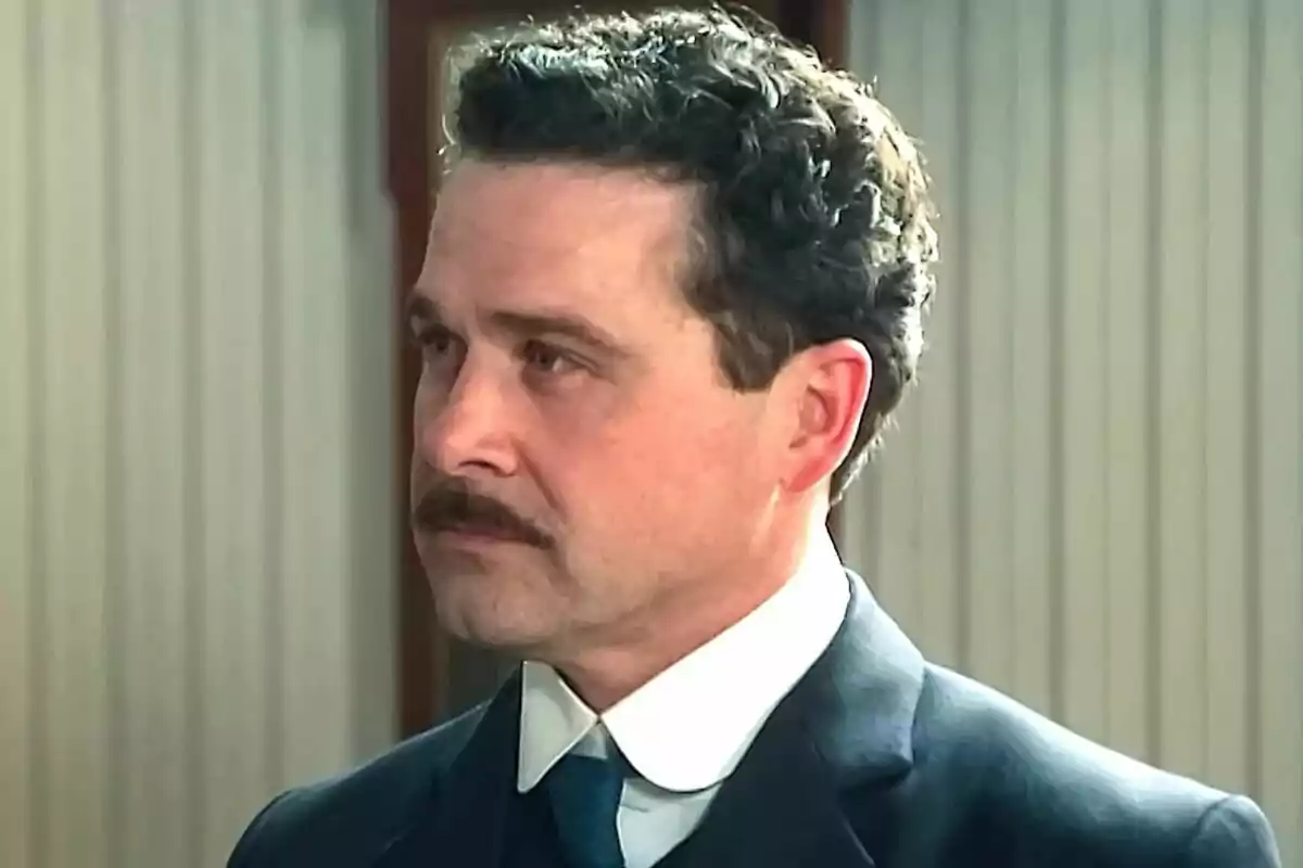 El actor Carlos de Austria con bigote y con expresión seria vestido con traje formal oscuro y camisa blanca. El actor Carlos de Austria con bigote y con expresión seria vestido con traje formal oscuro y camisa blanca.