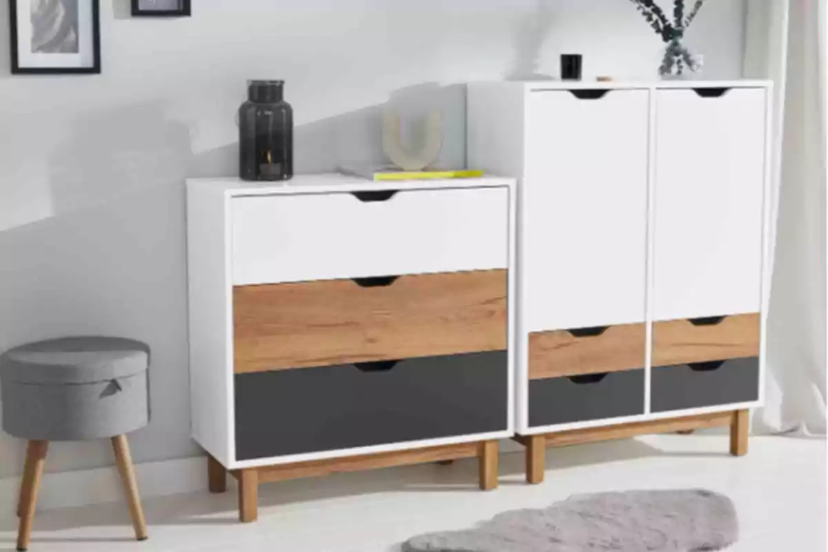 Muebles modernos de madera y blanco con cajones en tonos madera y negro junto a un banco gris y una alfombra en una habitación iluminada Muebles modernos de madera y blanco con cajones en tonos madera y negro junto a un banco gris y una alfombra en una habitación iluminada