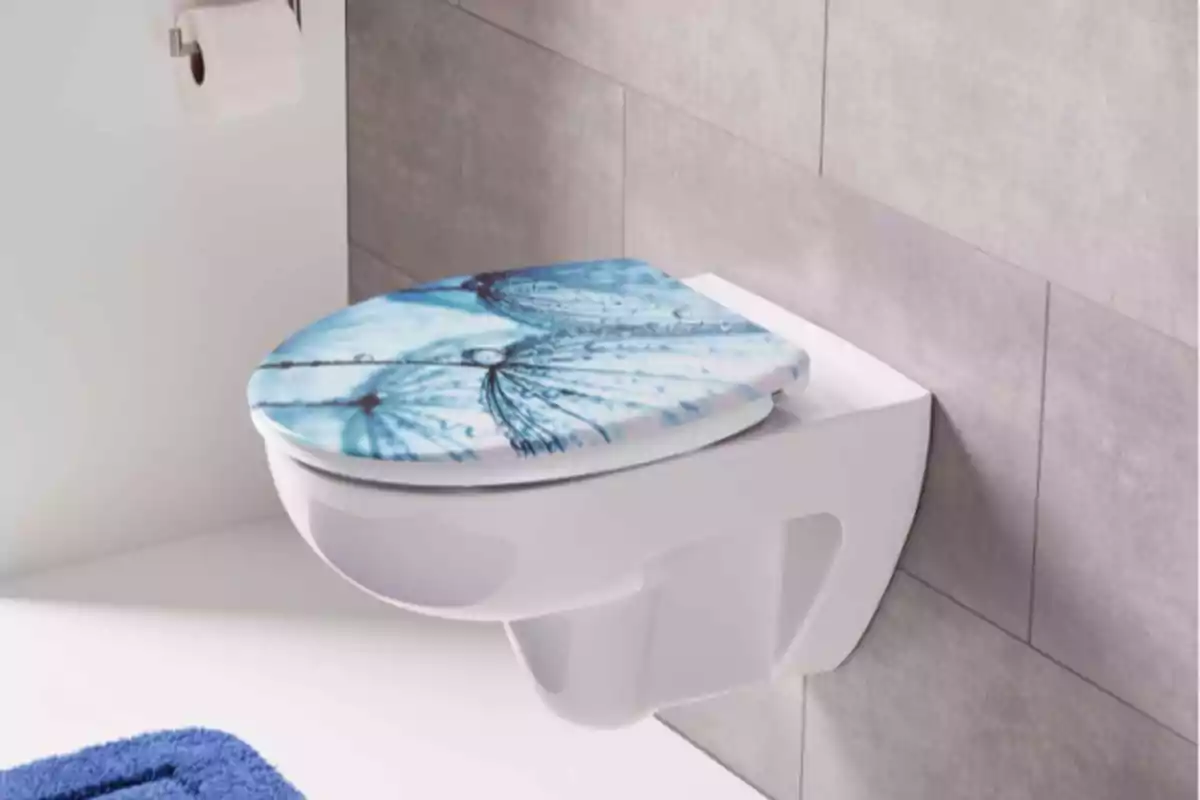 Inodoro blanco de pared con tapa decorada con mariposas azules en un baño moderno Inodoro blanco de pared con tapa decorada con mariposas azules en un baño moderno