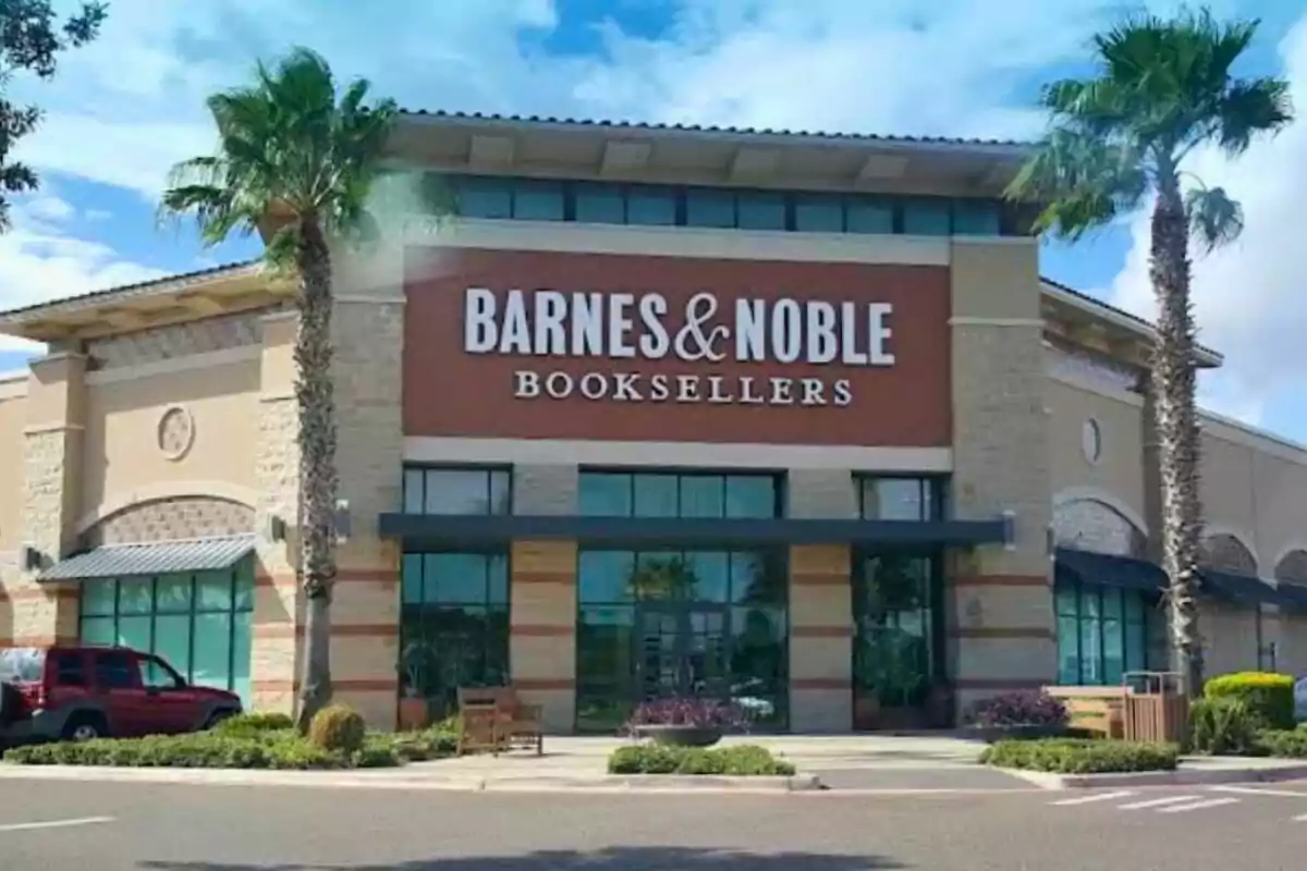 Facade of a Barnes and Noble bookstore surrounded by palm trees and a red car parked on the left Facade of a Barnes and Noble bookstore surrounded by palm trees and a red car parked on the left