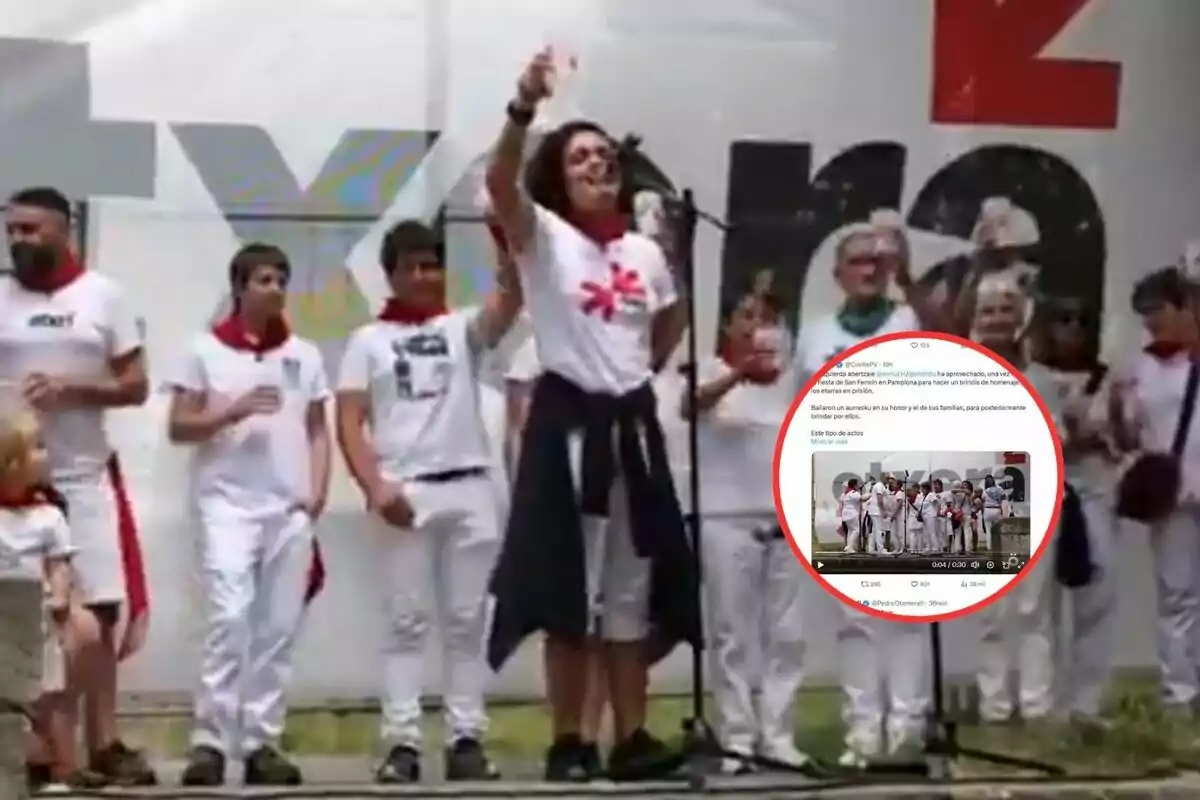 Grupo de personas vestidas de blanco con pañuelos rojos reunidas en un escenario al aire libre, una mujer al centro levanta un vaso mientras habla por un micrófono y en la imagen aparece un círculo rojo que resalta una publicación en redes sociales.