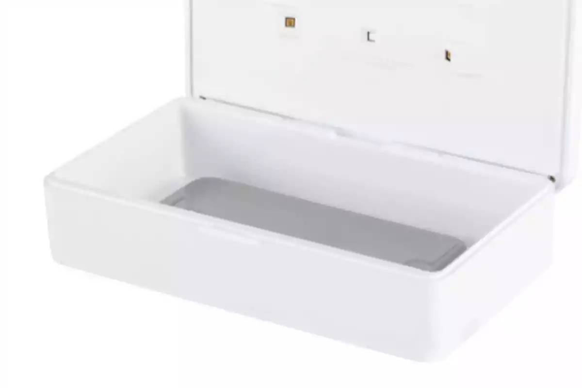 Caja blanca abierta con un teléfono móvil en su interior Caja blanca abierta con un teléfono móvil en su interior