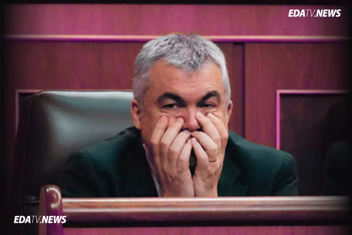 Hombre de cabello canoso sentado en un sillón con las manos cubriéndose parcialmente el rostro en un entorno de madera