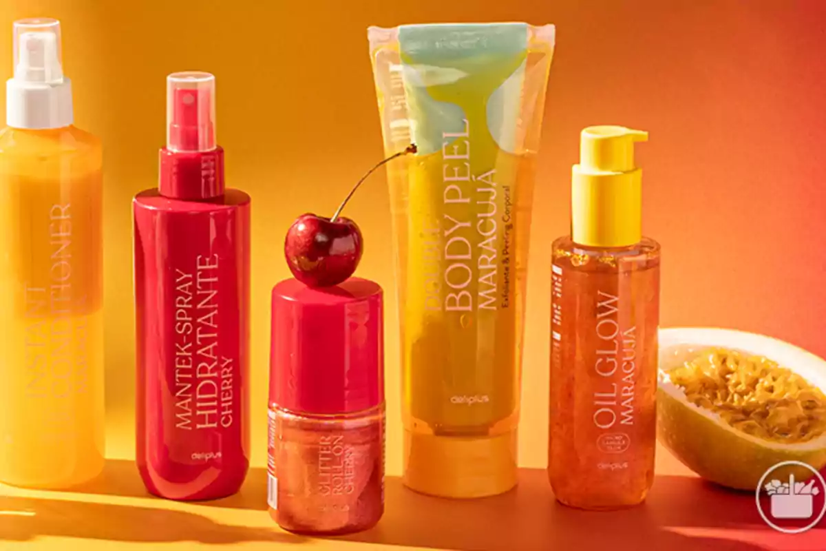 Cinco productos cosméticos de colores vibrantes con envases en tonos amarillo y rojo, acompañados de una cereza y medio maracuyá sobre un fondo naranja. Cinco productos cosméticos de colores vibrantes con envases en tonos amarillo y rojo, acompañados de una cereza y medio maracuyá sobre un fondo naranja.