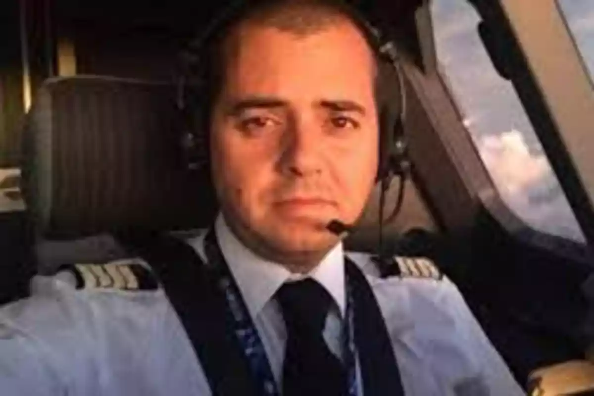 Piloto con uniforme y auriculares sentado en la cabina de un avión Piloto con uniforme y auriculares sentado en la cabina de un avión