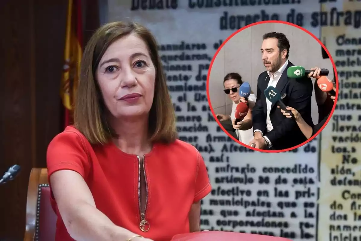 Mujer de cabello castaño y vestido rojo sentada frente a un micrófono con fondo de texto borroso y bandera de España, en la esquina superior derecha aparece un recuadro con un hombre rodeado de micrófonos de diferentes medios de comunicación