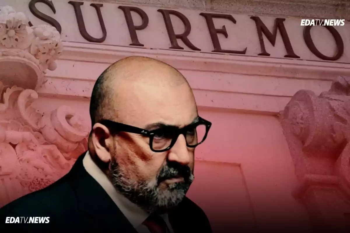 Hombre con gafas y barba en primer plano con la palabra SUPREMO en el fondo sobre una fachada de edificio antiguo