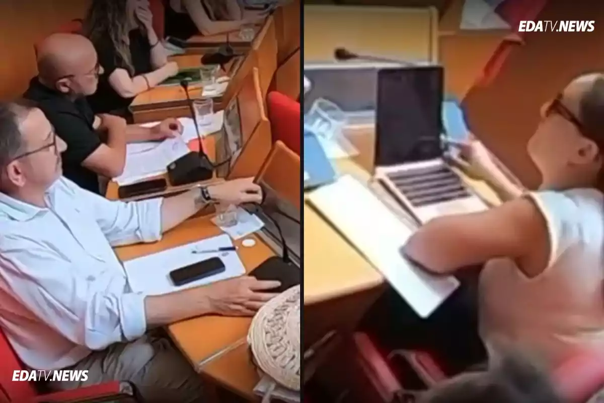 Varias personas sentadas en escritorios de una sala de reuniones usando computadoras portátiles y tomando notas