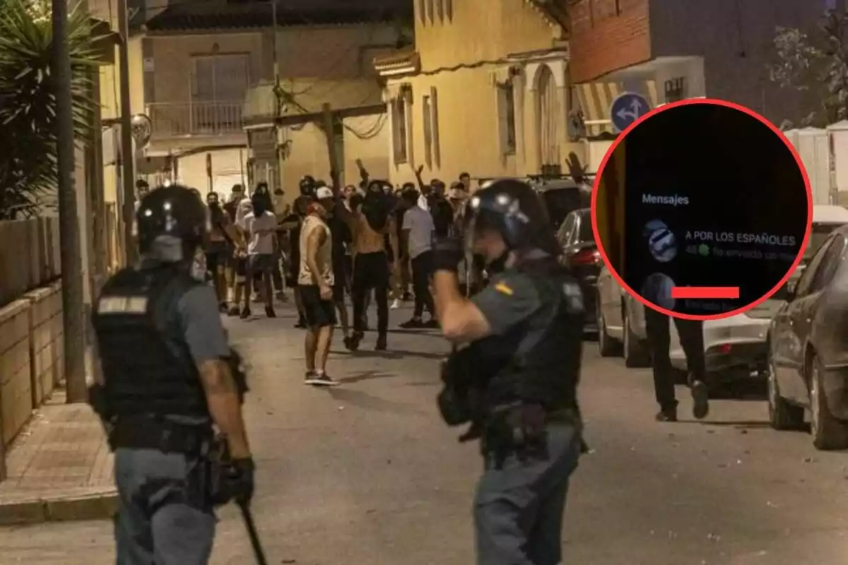 Policías antidisturbios observan a un grupo de personas en una calle durante la noche mientras en un círculo se muestra un mensaje de chat en un teléfono móvil