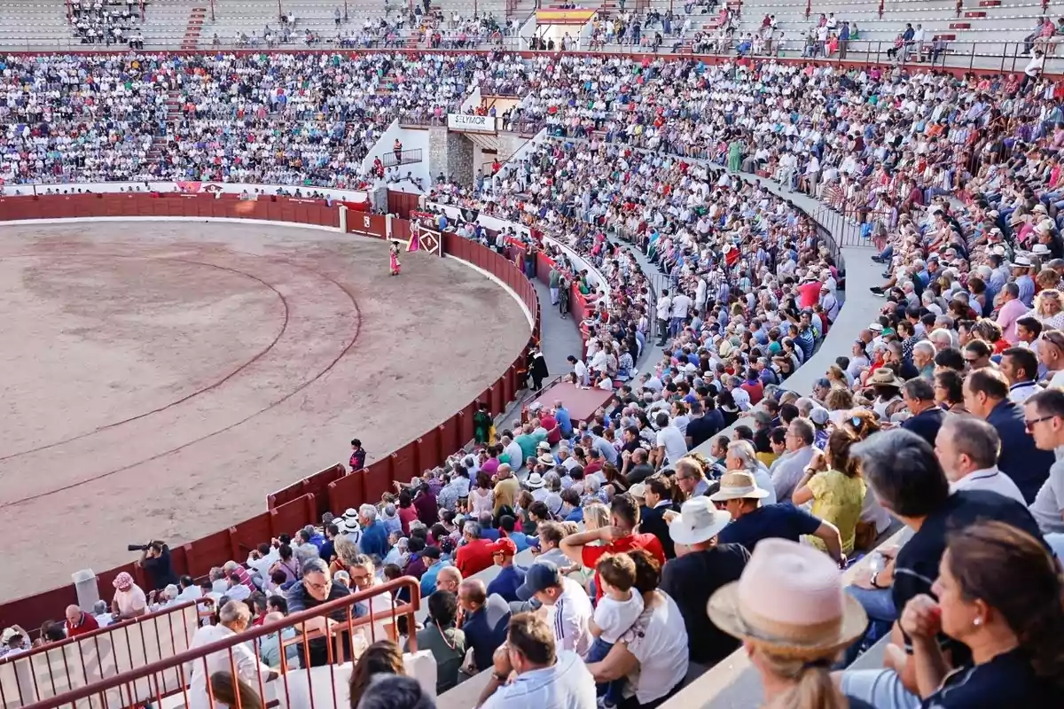 Gradas llenas de personas observando un evento en una plaza de toros Gradas llenas de personas observando un evento en una plaza de toros