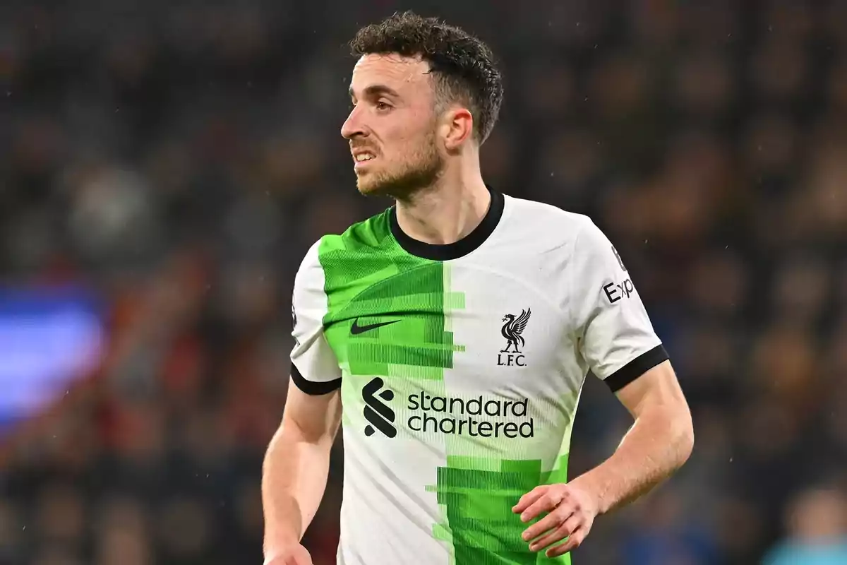 Futbolista con uniforme blanco y verde del Liverpool durante un partido