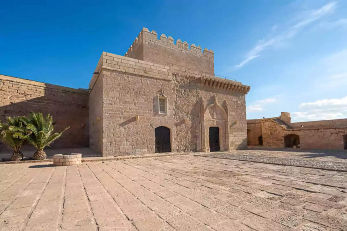 Fortaleza de piedra antigua con muros altos y almenas bajo un cielo despejado