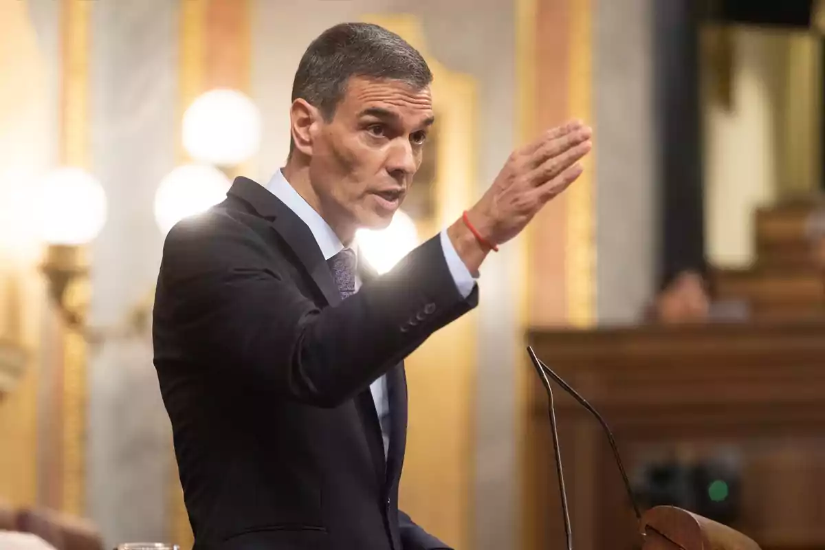 Hombre de traje hablando y gesticulando en un parlamento