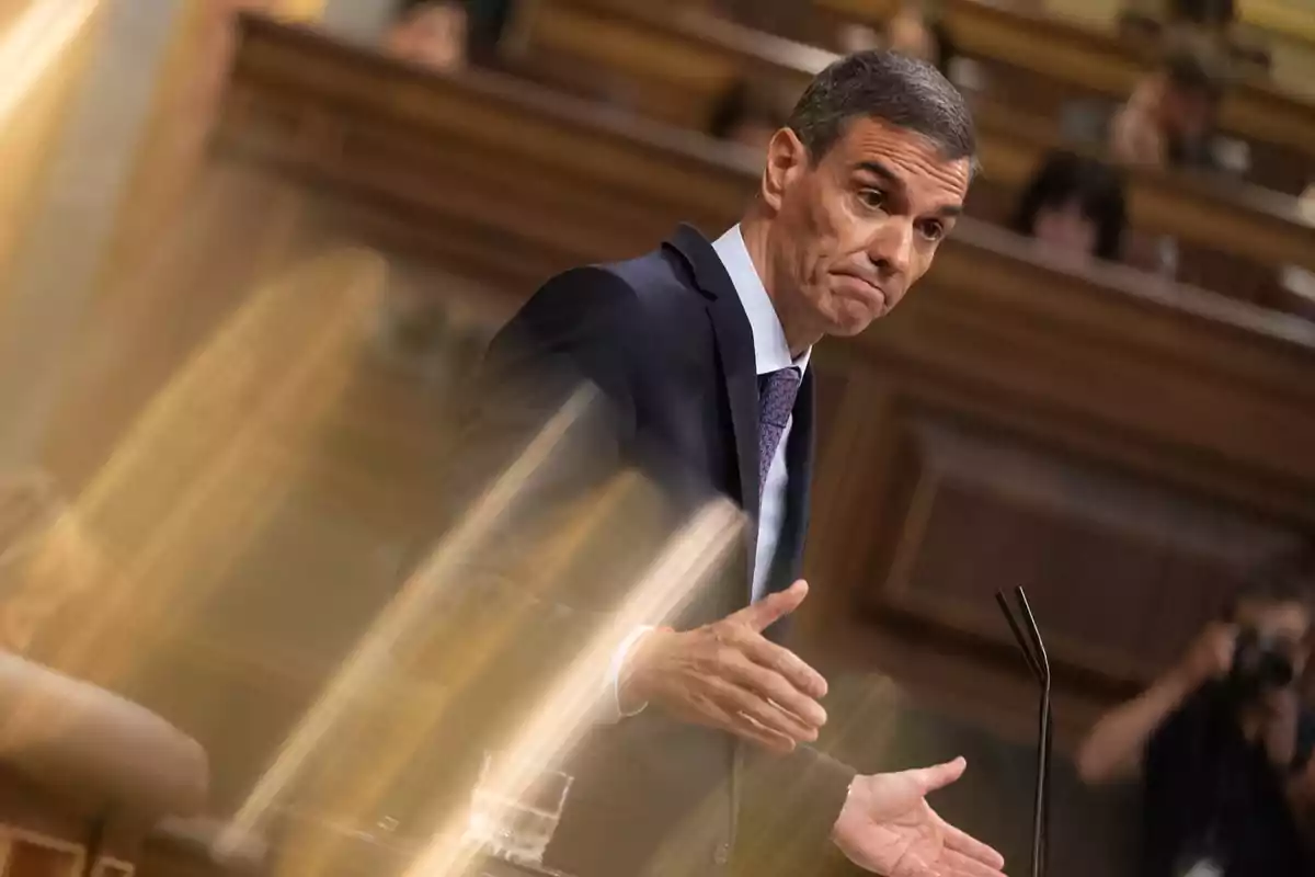 Hombre de traje hablando en un parlamento con gesto serio y fondo desenfocado Hombre de traje hablando en un parlamento con gesto serio y fondo desenfocado