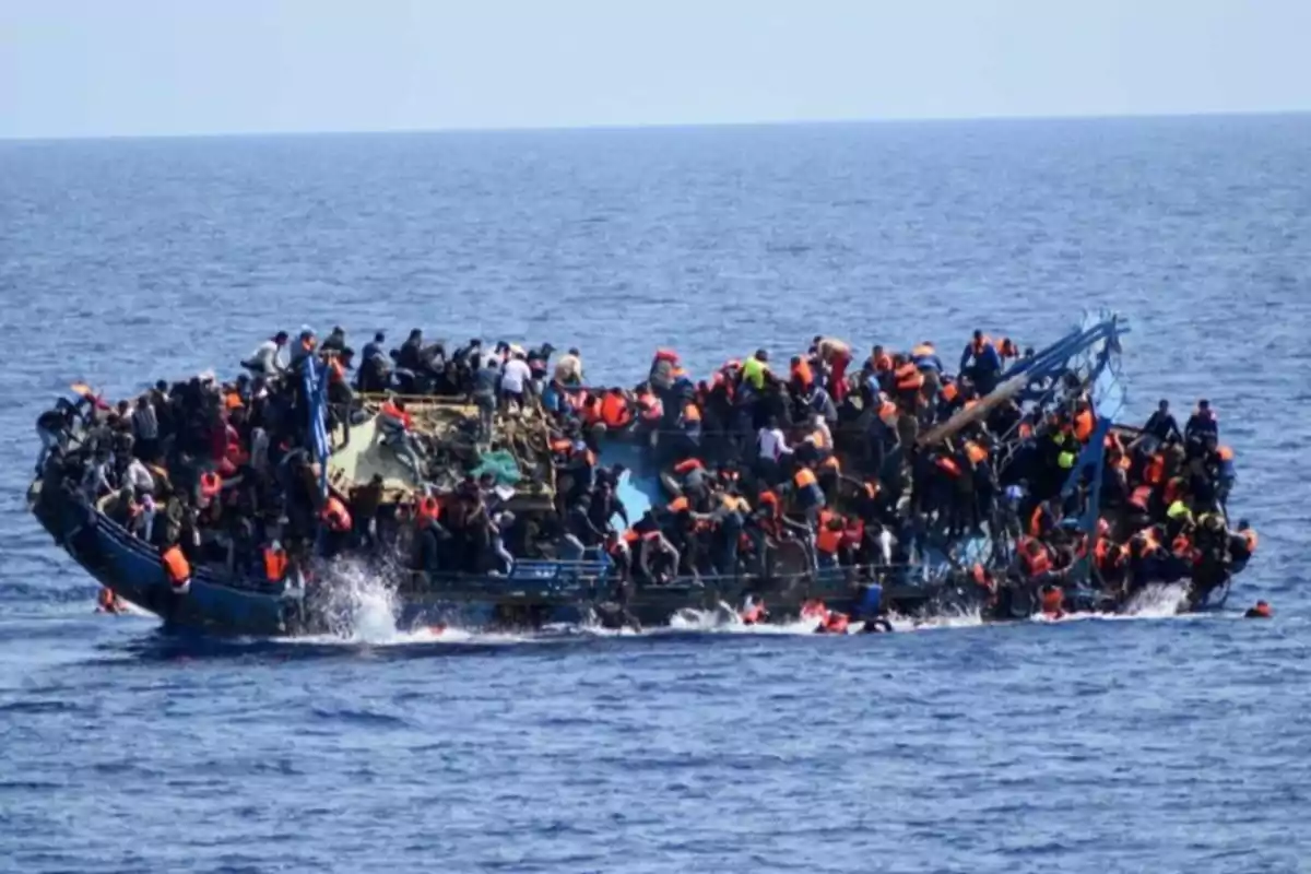 Barco sobrecargado de personas con chalecos salvavidas en el mar Barco sobrecargado de personas con chalecos salvavidas en el mar
