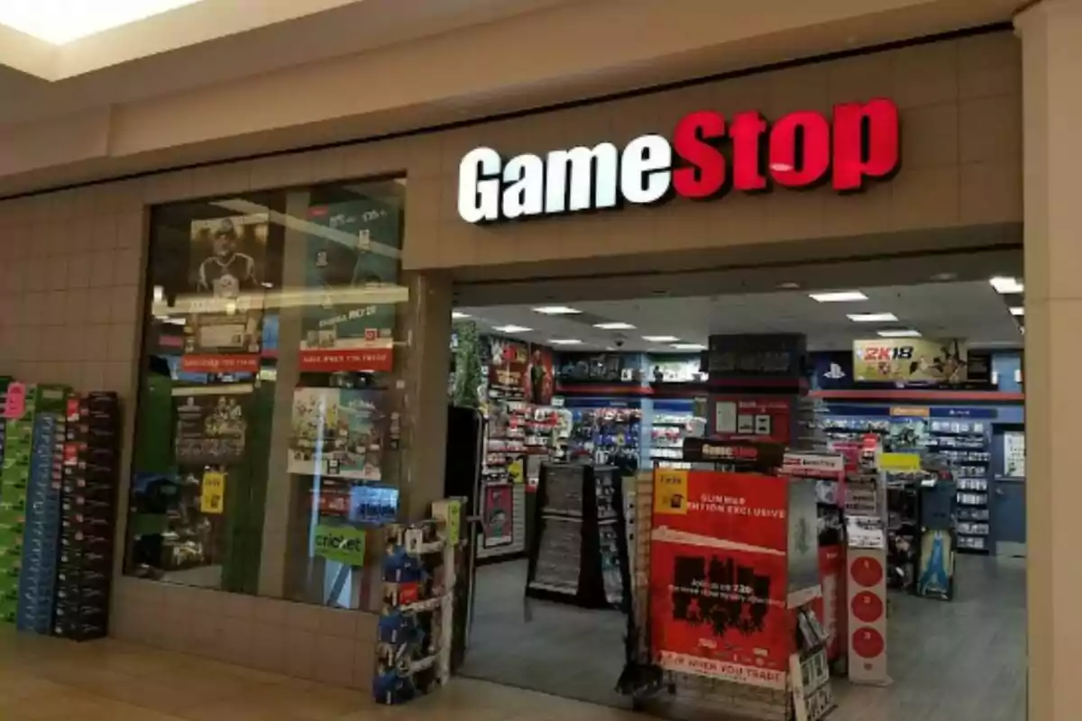 Fachada de una tienda GameStop en un centro comercial con carteles promocionales y estantes de videojuegos visibles en el interior Fachada de una tienda GameStop en un centro comercial con carteles promocionales y estantes de videojuegos visibles en el interior