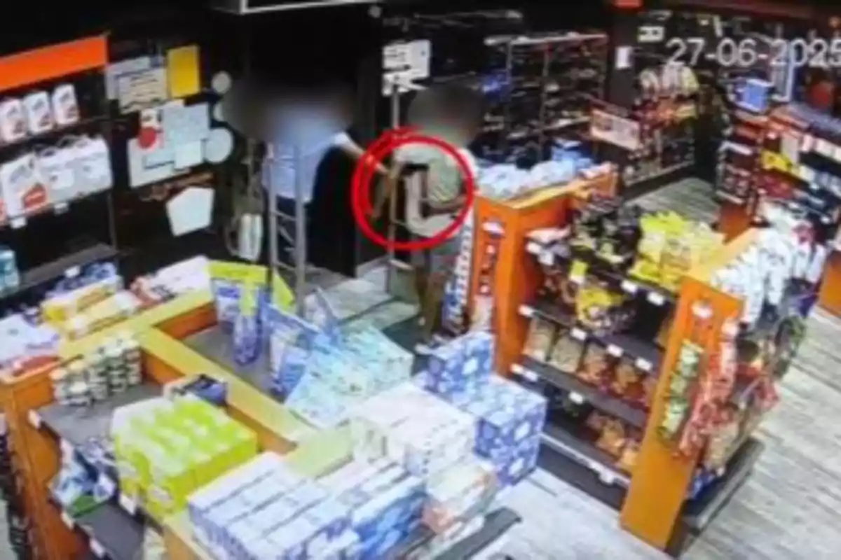 Imagen de una tienda de conveniencia captada por una cámara de seguridad donde dos personas están cerca de la entrada y una de ellas está rodeada por un círculo rojo Imagen de una tienda de conveniencia captada por una cámara de seguridad donde dos personas están cerca de la entrada y una de ellas está rodeada por un círculo rojo