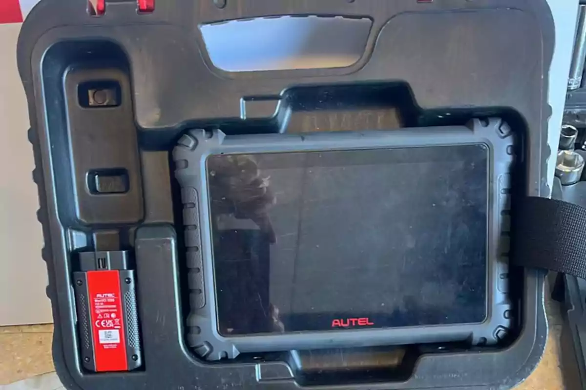 Maletín negro con un escáner automotriz de la marca Autel y un conector OBD rojo en su interior Maletín negro con un escáner automotriz de la marca Autel y un conector OBD rojo en su interior
